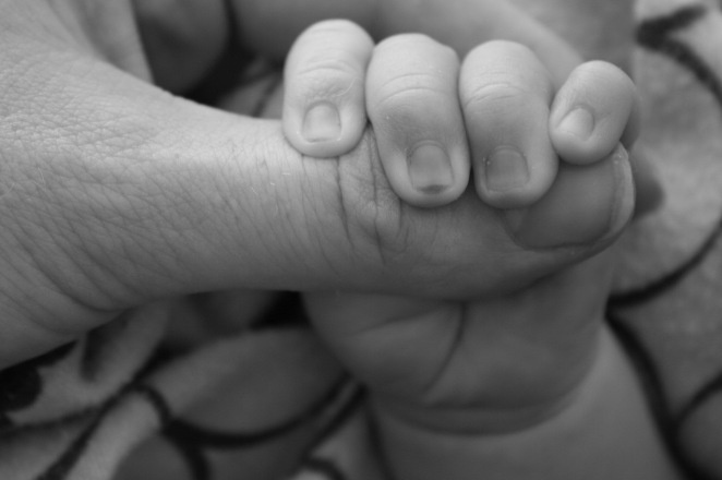 Novorođenče se čvrsto drži za majčinu ruku